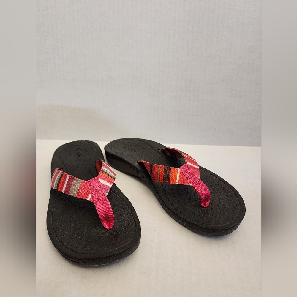 GENTLY USED CLARKS FLIP FLOPS IN MULTI COLORED STRIPE, SIZE 7.